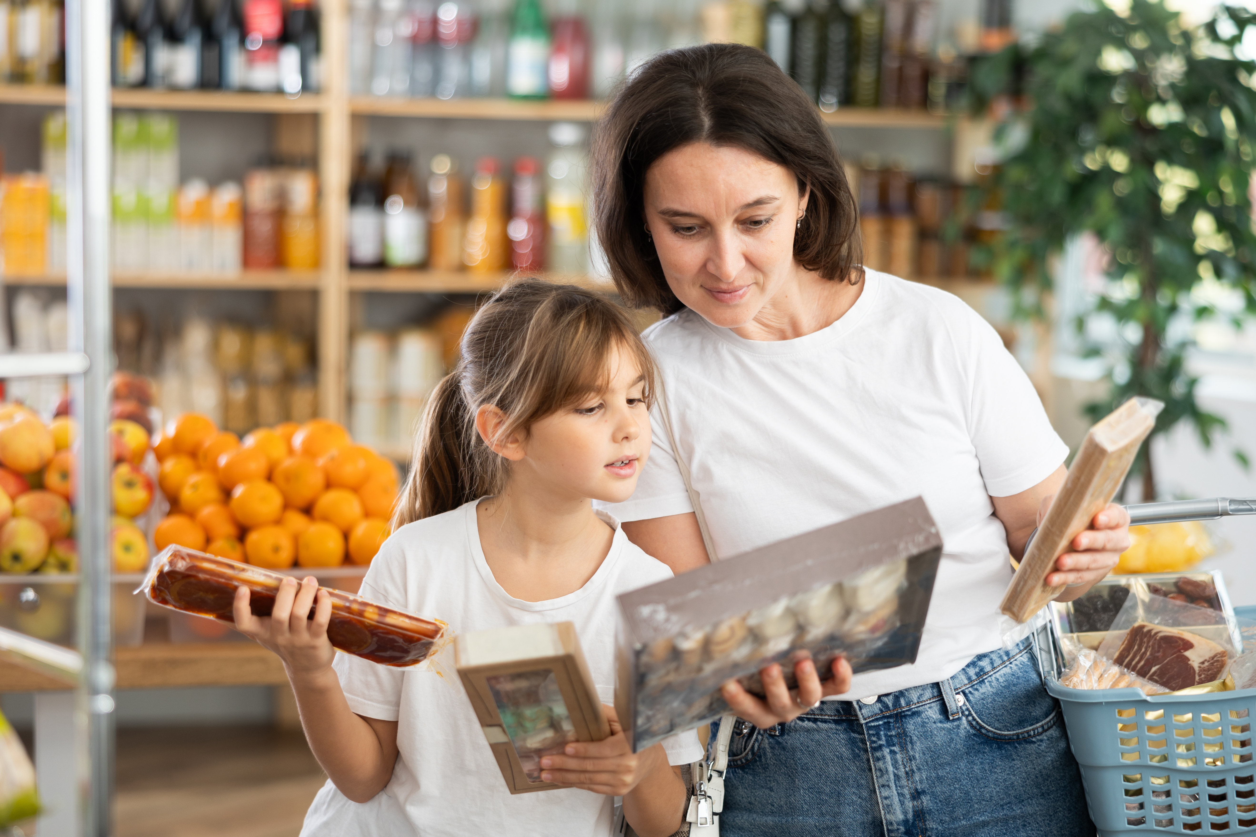 A mother and daughter reading food labels while shopping