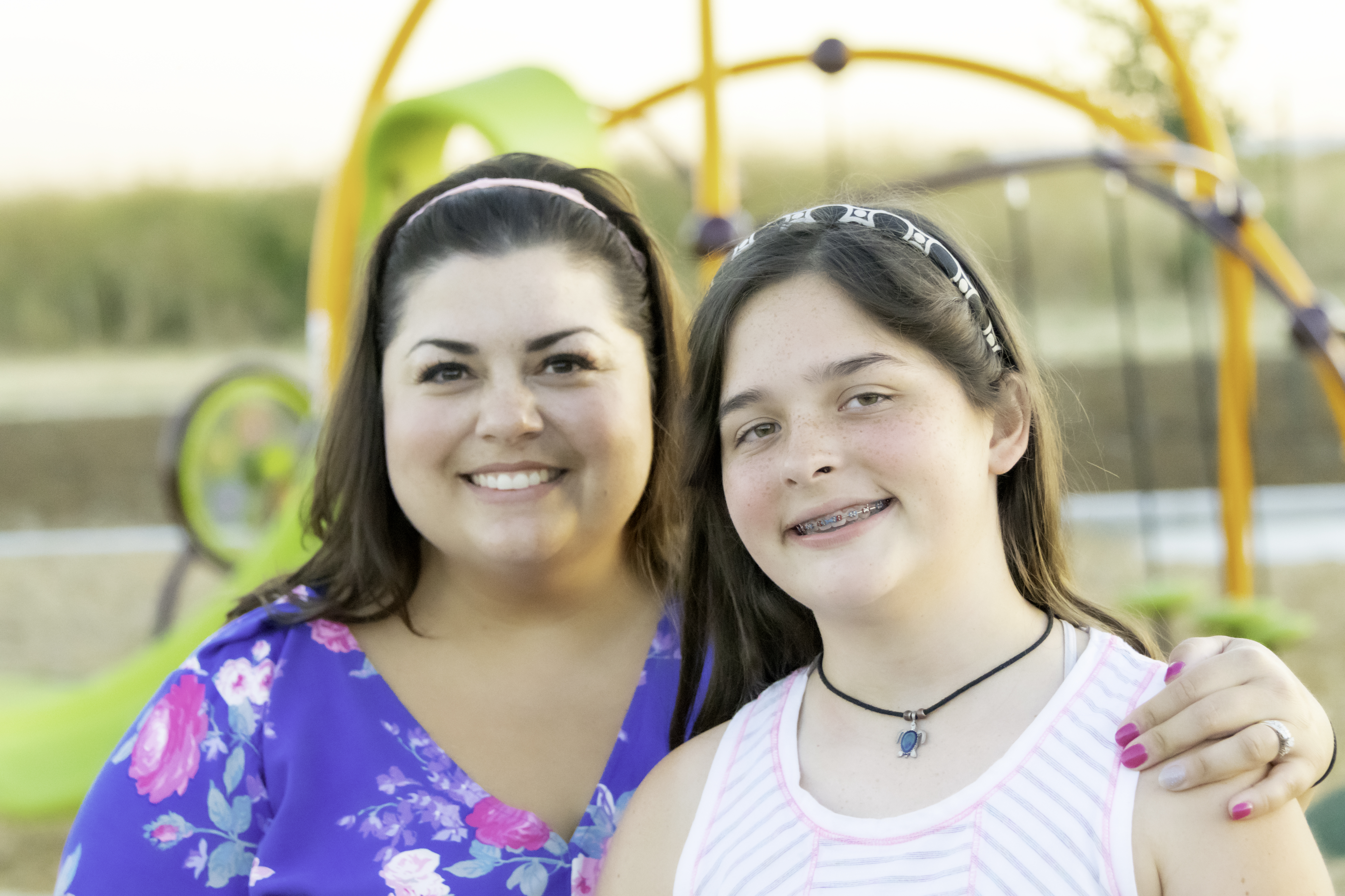 A mother and daughter smiling together outdoors