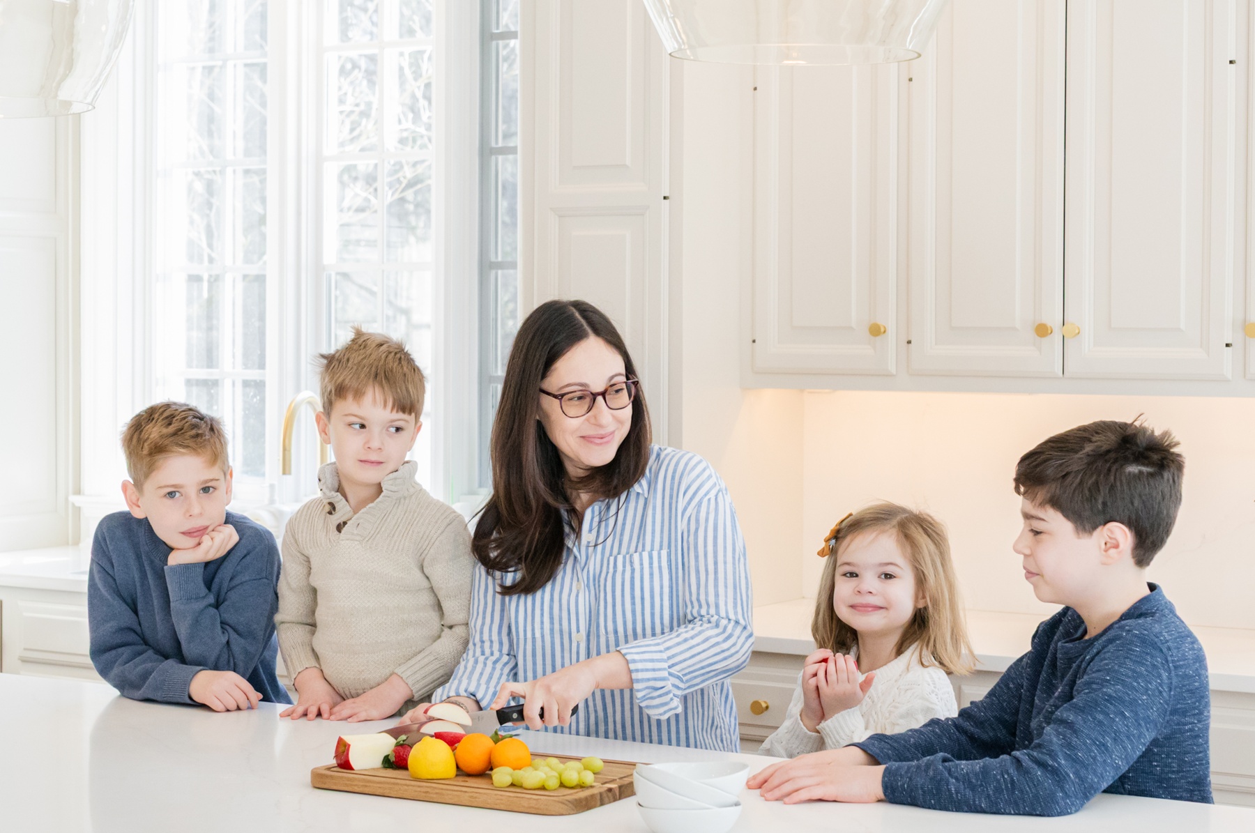 Family preparing fruit together in a bright kitchen