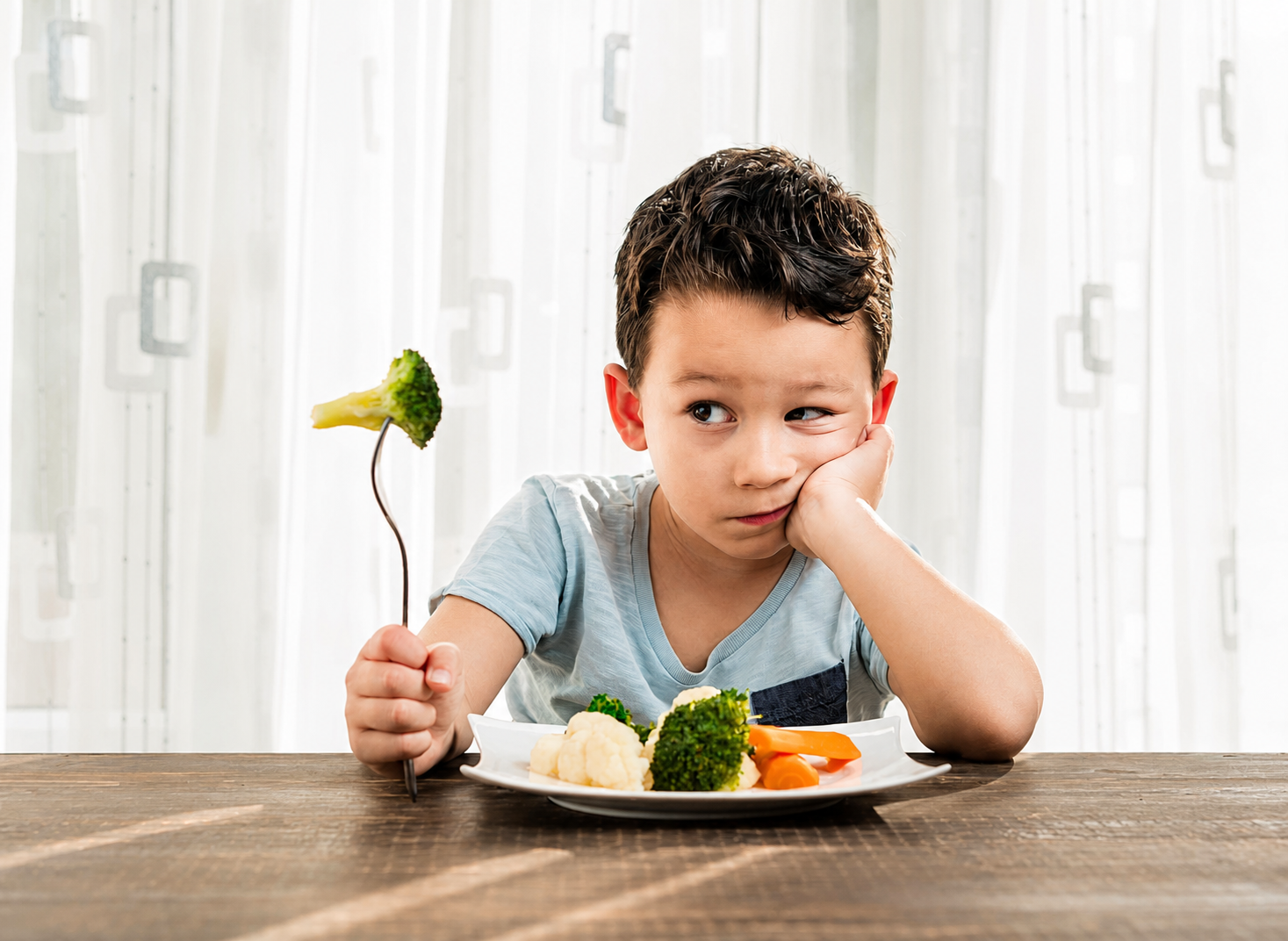 Young child considering a plate of vegetables